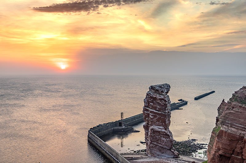 De rotsnaald Lange Anna voor de golfbreker van Helgoland bij zonsondergang