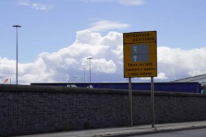 Verkeersbord langs de weg bij de haven die aangeeft dat het belangrijk is om links te rijden