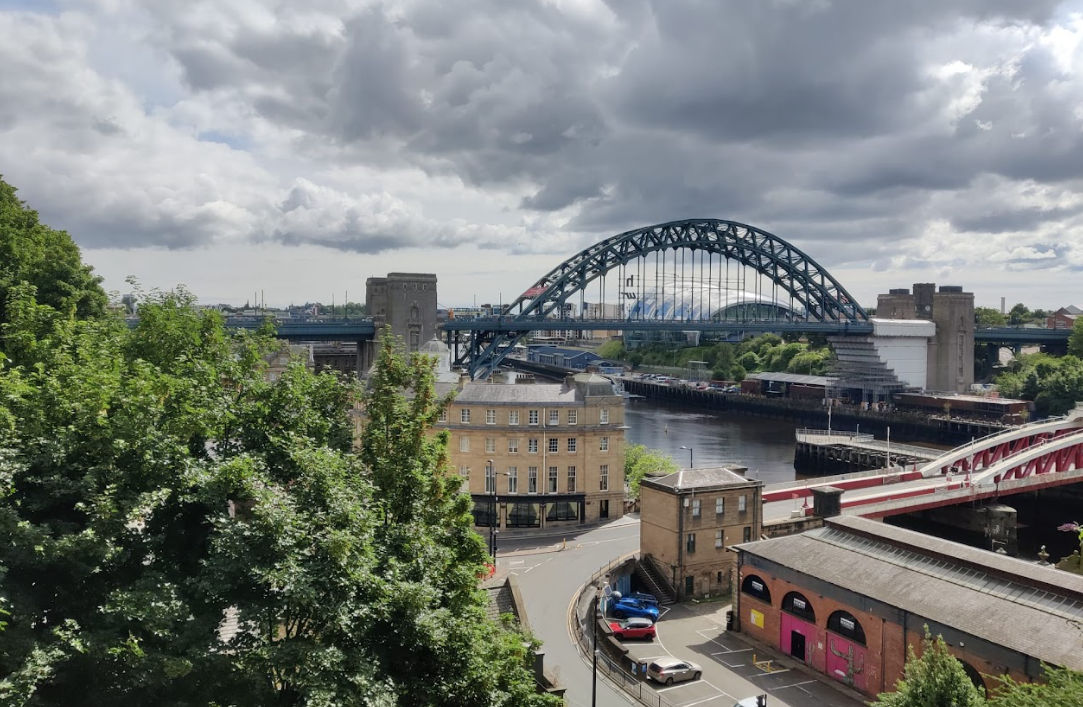 De Tyne Bridge over de rivier bij Newcastle, met de rode Swing Bridge op de voorgrond
