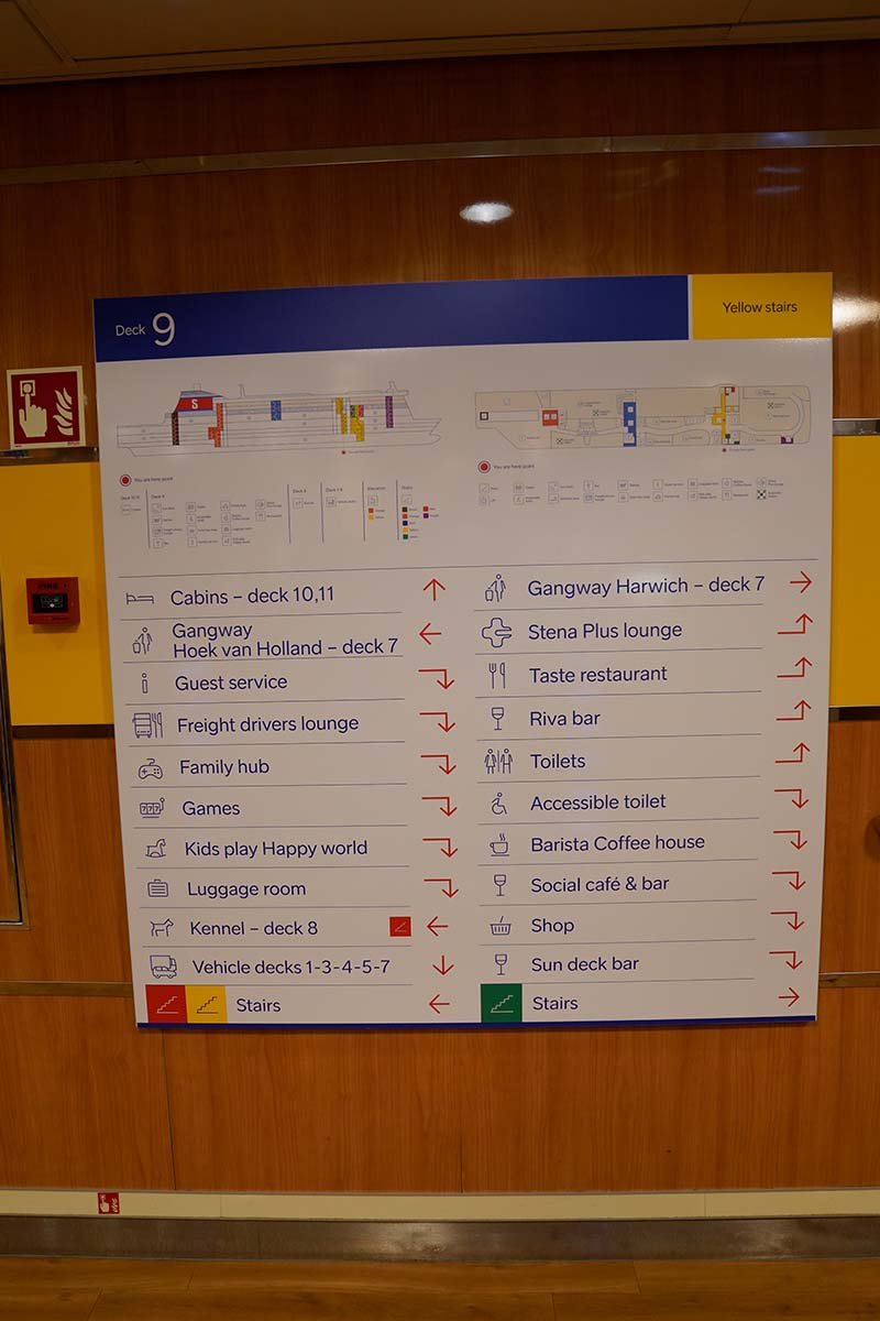 Wegwijsbord op dek 9 met plattegronden en een lijst: hutten op dek 10 en 11, de gangways naar Hoek van Holland en Harwich op dek 7, de kennel op dek 8, en verder restaurant, lounge, winkel, Family hub en Happy world
