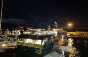 Veerboot in de nacht aan de kade met sterren in de lucht.