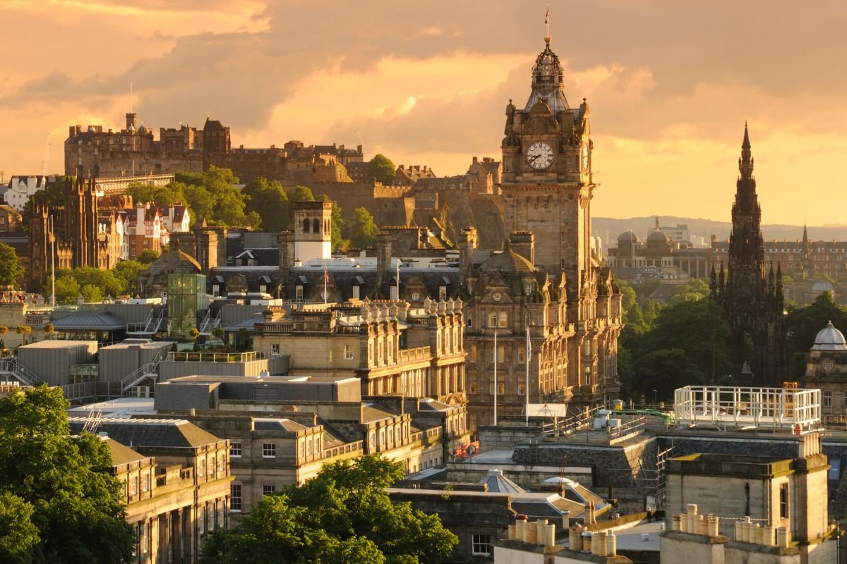 De daken van Edinburgh in avondlicht, met het kasteel en de klokkentoren