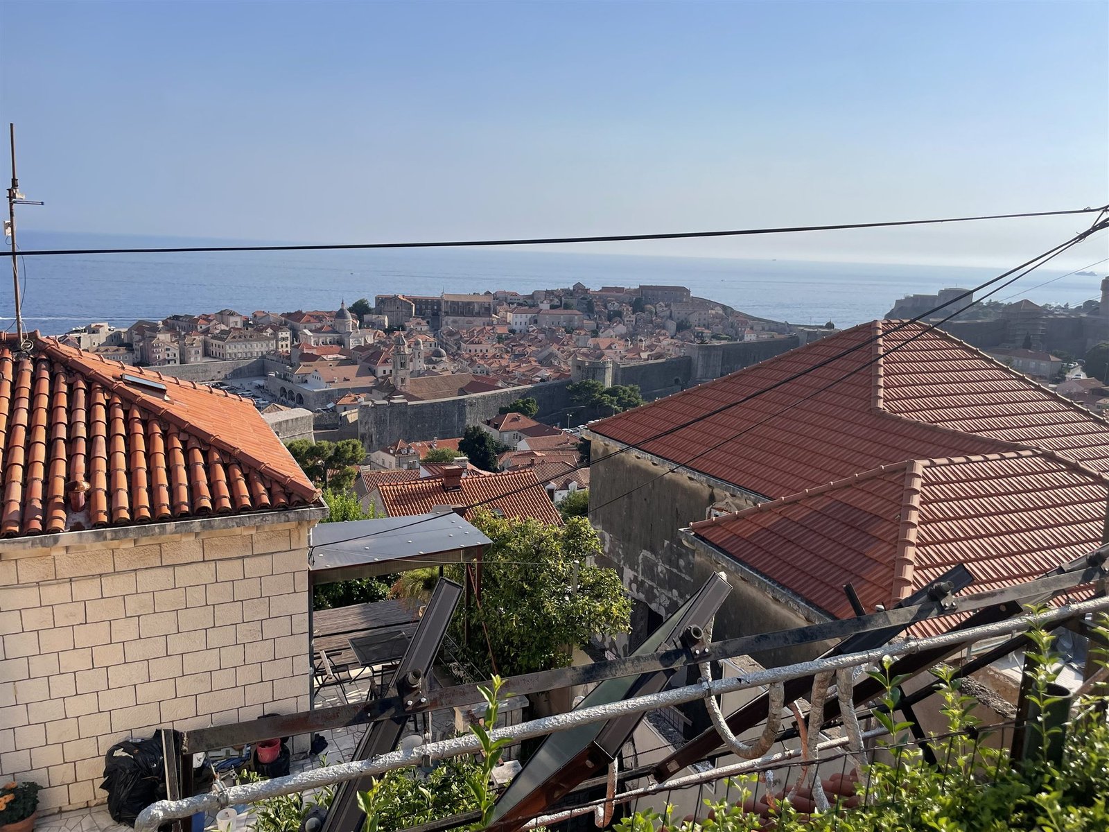 Uitzicht over de daken op de ommuurde oude stad van Dubrovnik en de zee