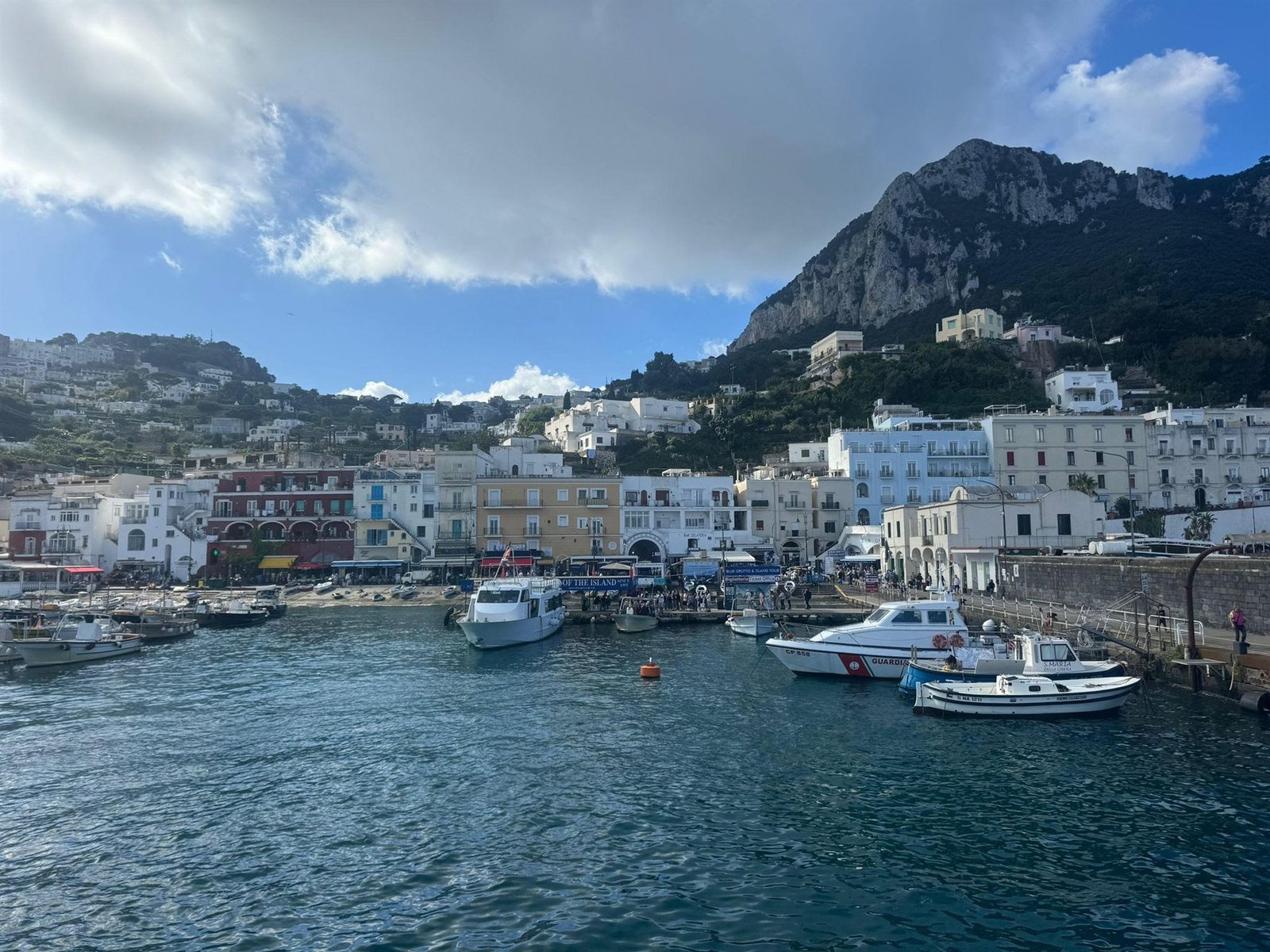 De haven van Marina Grande op Capri met vissersboten, gekleurde huizen en de rotsen erboven
