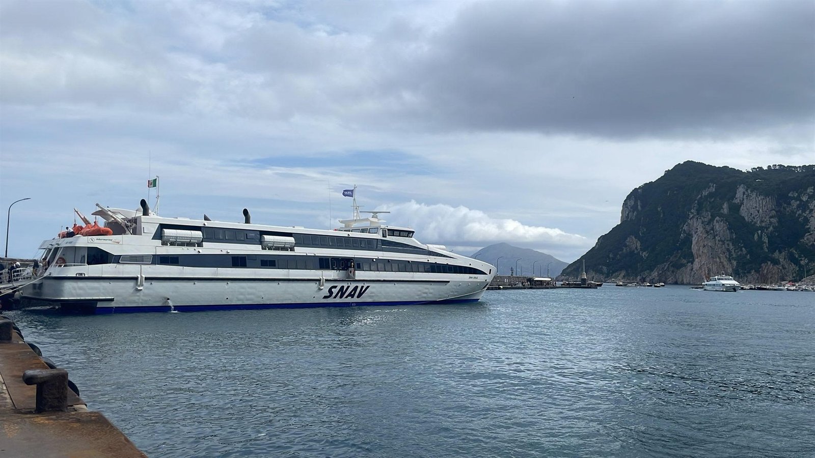 De draagvleugelboot van SNAV aan de kade van Marina Grande op Capri, met de kliffen van het eiland erachter