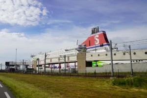 Een Stena Line-veerboot aan de kade in Hoek van Holland, achter het terminalgebouw met de loopbruggen, met het metrospoor op de voorgrond