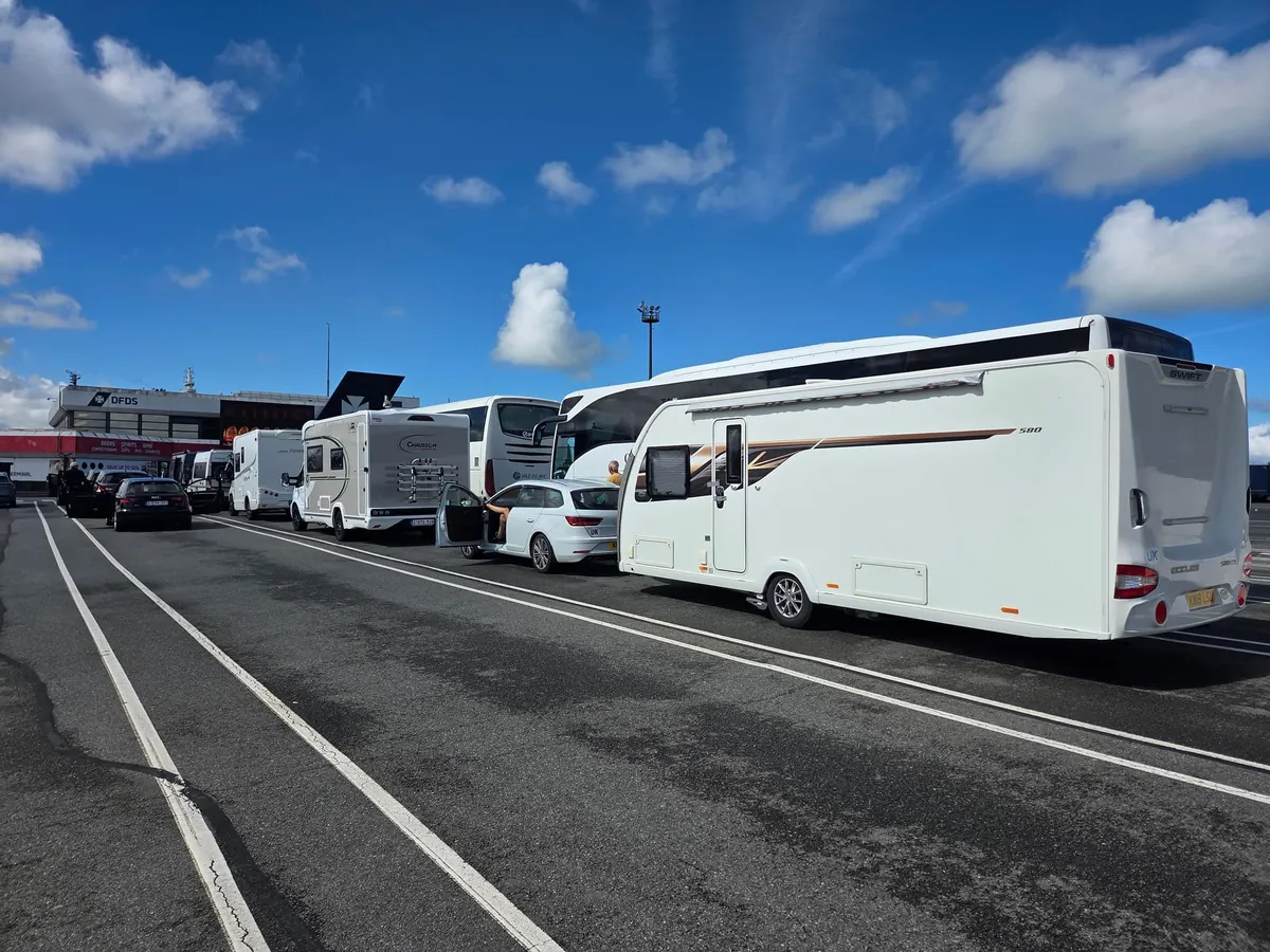 Een caravan, campers, een bus en auto’s in de rij op het terrein van de DFDS-terminal