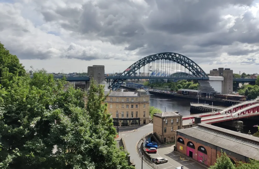 De Tyne Bridge over de rivier bij Newcastle, met de rode Swing Bridge op de voorgrond