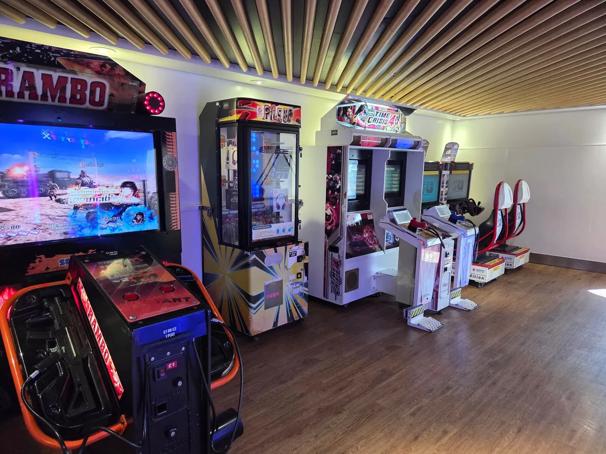 De speelhal aan boord van de Delft Seaways met arcadekasten, een racespel en een grijpautomaat