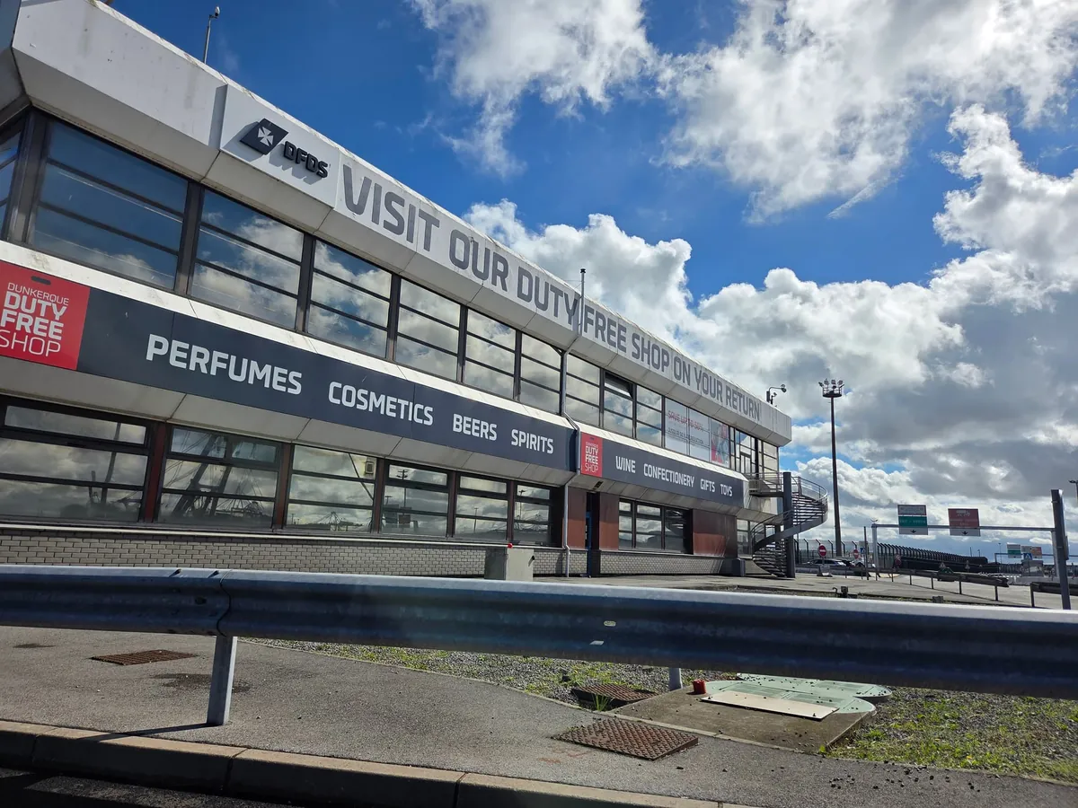 Het terminalgebouw van DFDS in Duinkerken met op de gevel Visit our duty free shop en de winkel met parfum, cosmetica, bier en sterke drank
