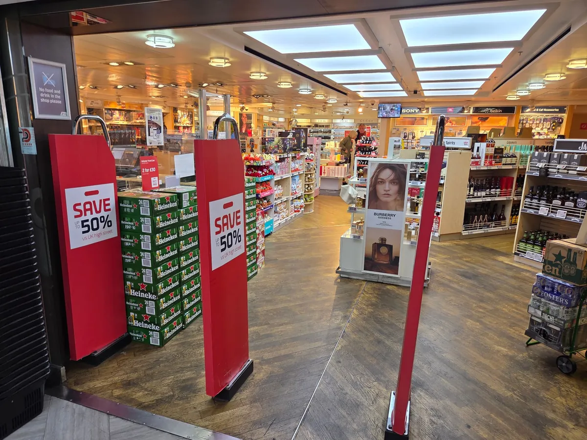 Een winkel met bier, sterke drank en parfum, en bij de ingang rode borden met 50 procent korting